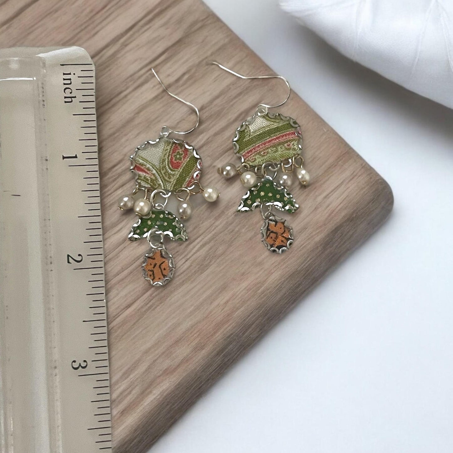 Handmade earrings featuring green and white polka dot fabric with peach and cream paisley and dangling faux pearls. Sterling ear wires.