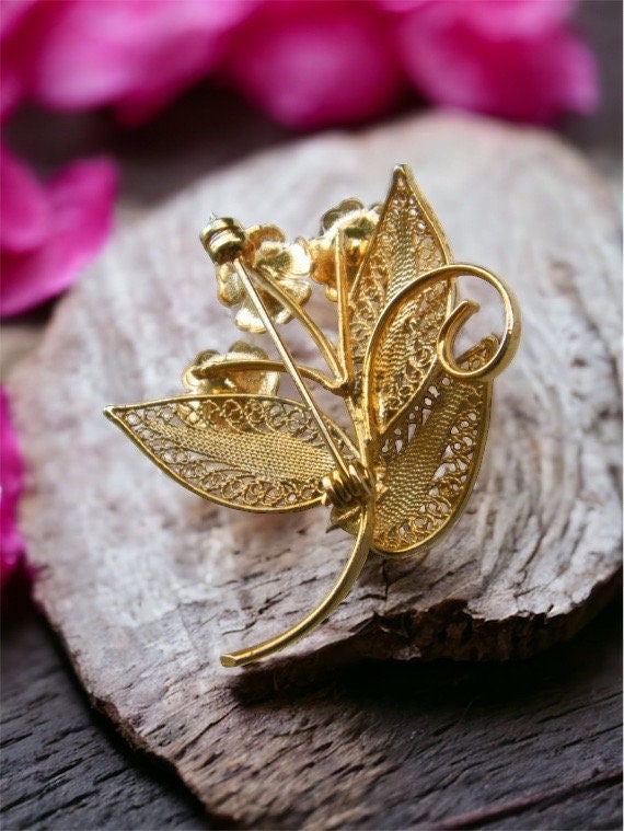 Detailed vintage filigree floral pin with faux pearls