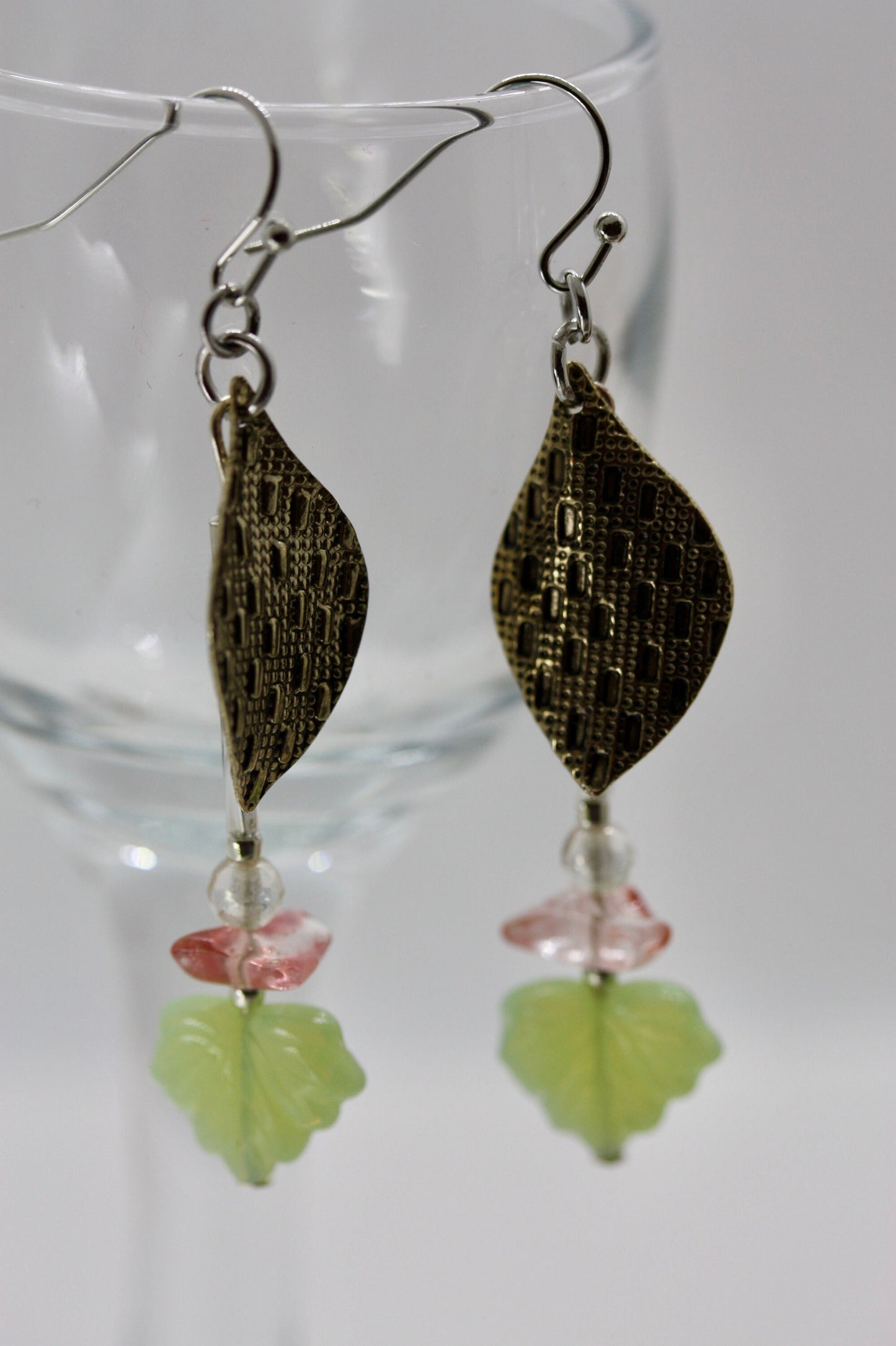 Handmade dangle earrings made of vintage textured metal leaves, pink gemstone chips and light green opaline glass ginko flower leaves