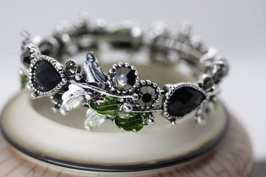 Stunning vintage costume jewelry cuff bracelet with black stones on silver with green leaves