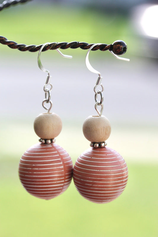 Scandinavian-inspired dangle earrings made of upcycled vintage coral colored striped bead with metal spacers and wood