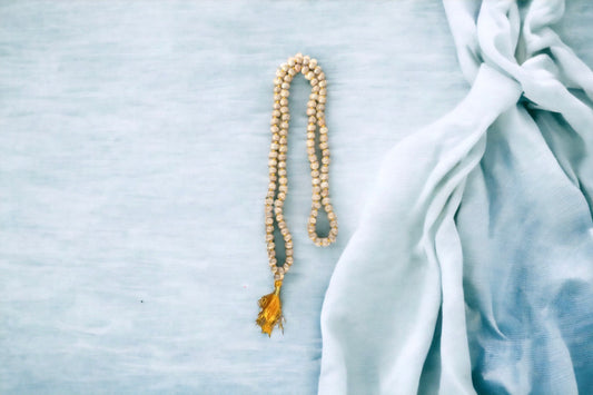 Knotted natural wood prayer bead necklace with golden yellow tassel