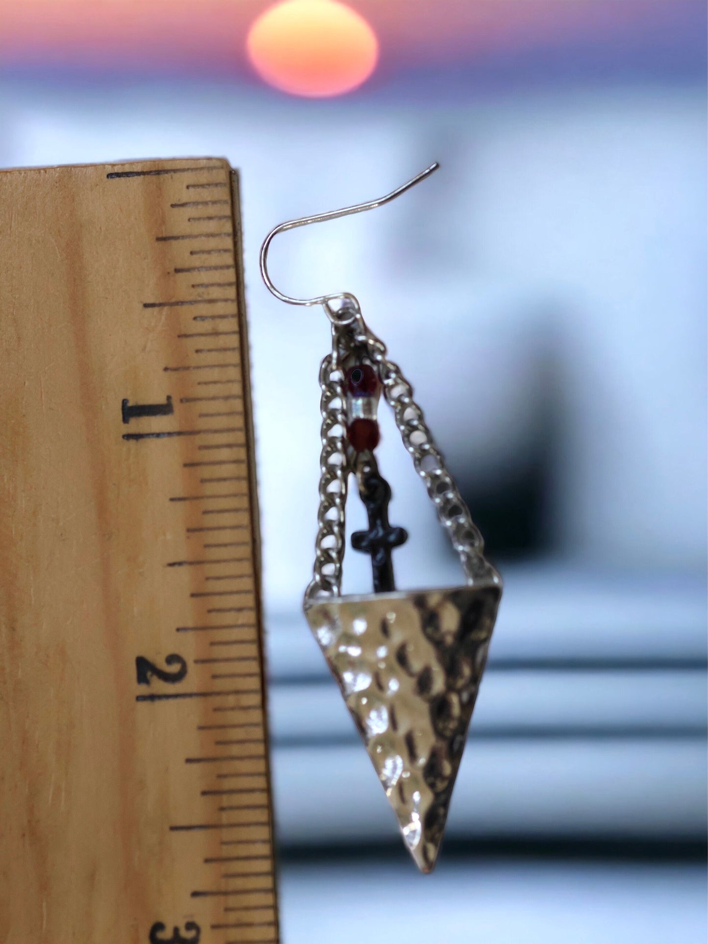 Hammered metal triangular dangle earrings with tiny crosses hanging from glass seed beads