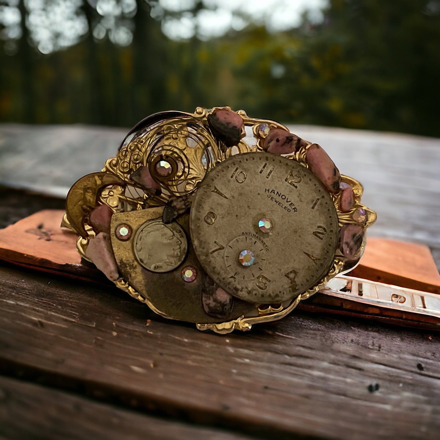 Assemblage art vintage pin with clock, rhinestones and other found pieces including semi precious stones on a filigree backing