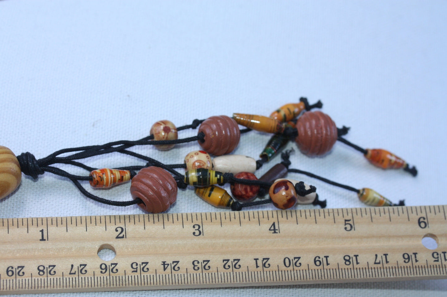 Long vintage wood, paper, glass mixed material vintage tassel necklace on black satin