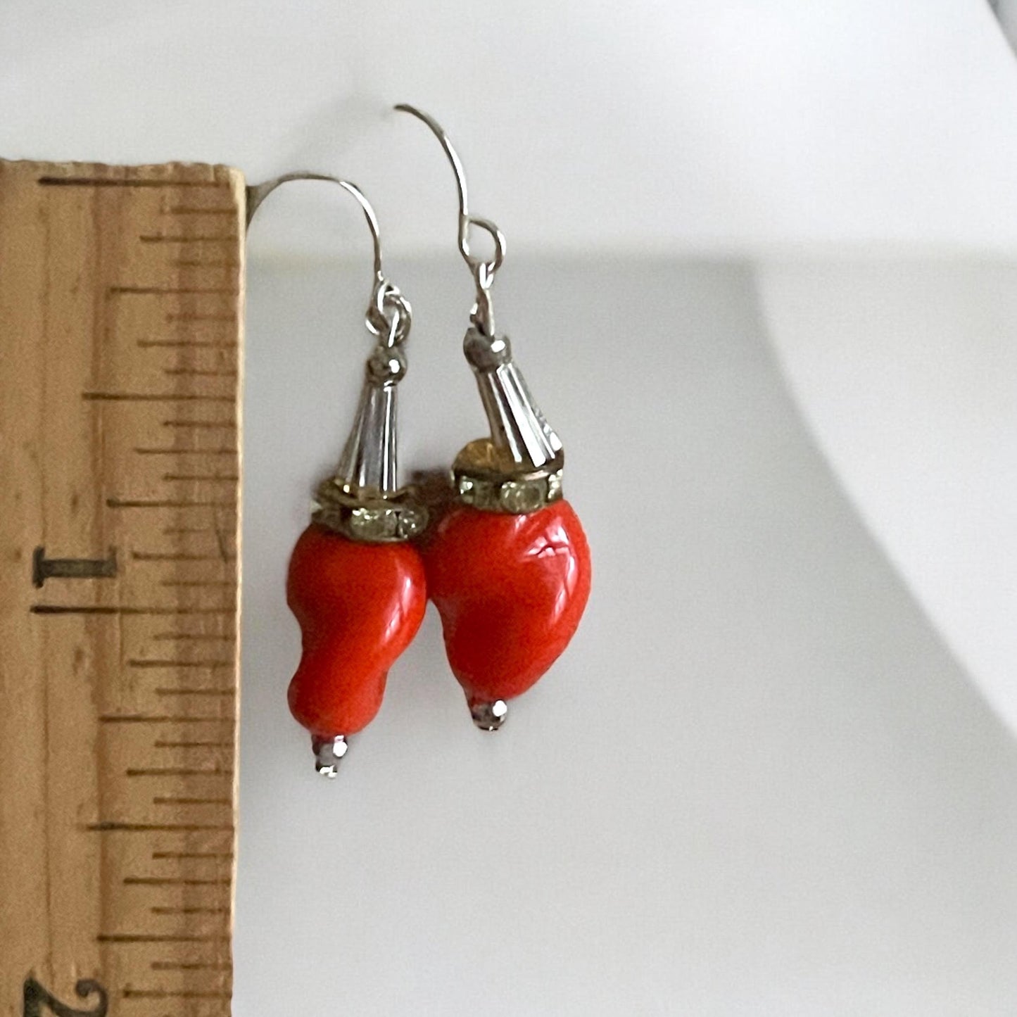 Unique dangle earrings featuring orange free form slightly twisted vintage glass, metal cone beads and rhinestone spacers