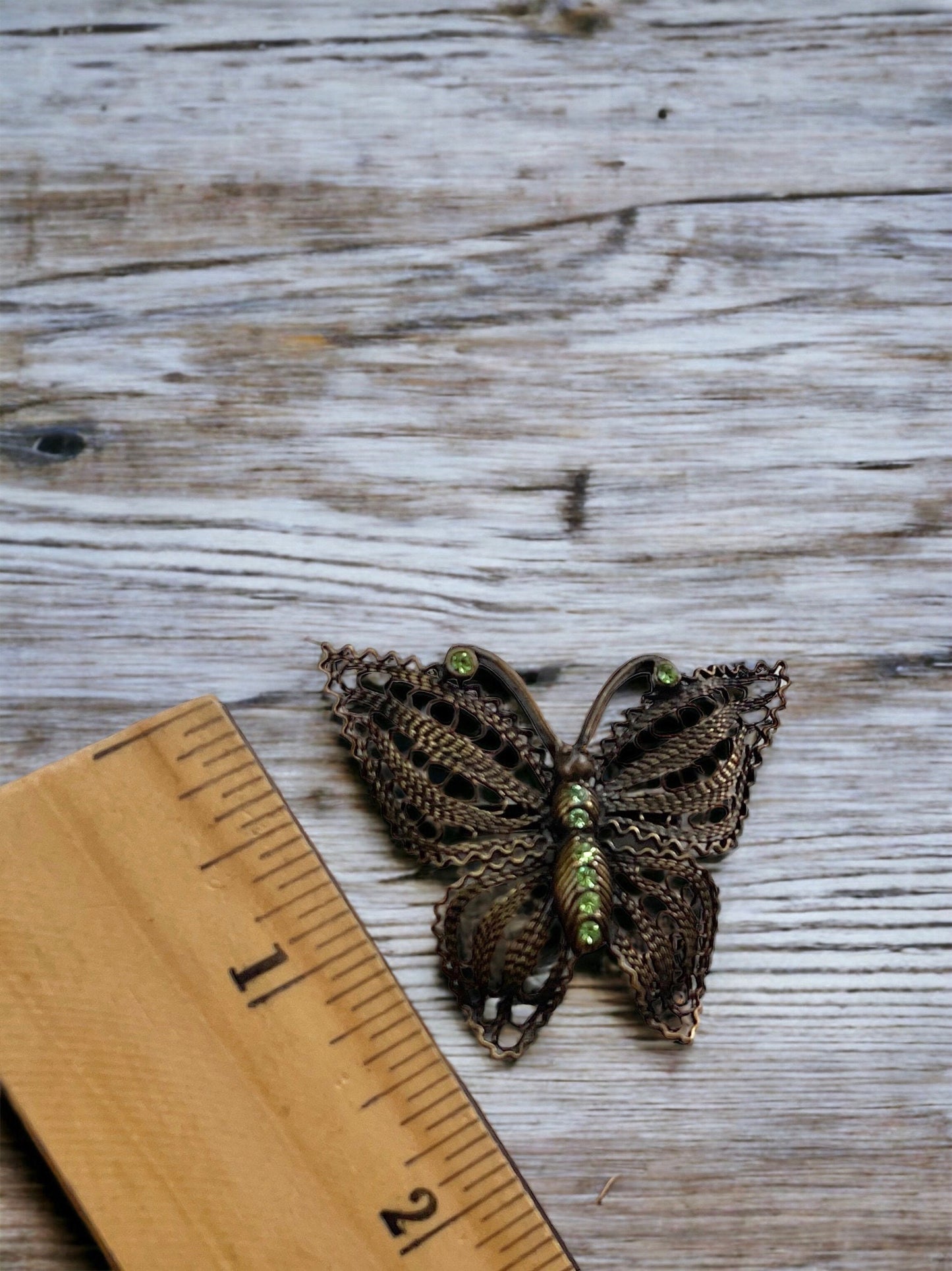 Detailed vintage filigree butterfly pin with tiny emerald green rhinestones