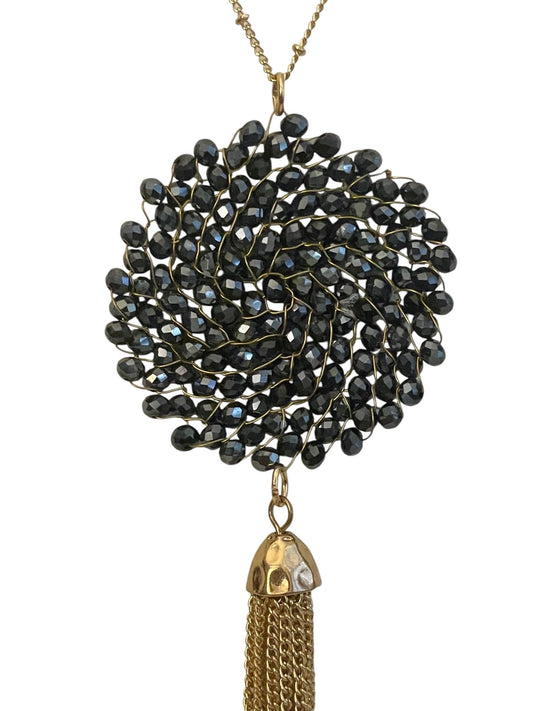 Vintage necklace featuring a black crystal wire linked circular pendant with long goldtone tassel