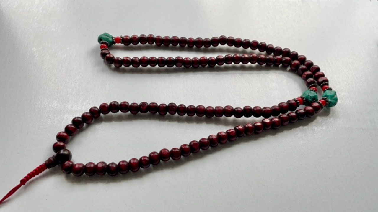 Long turquoise and wood vintage beaded necklace on red satin