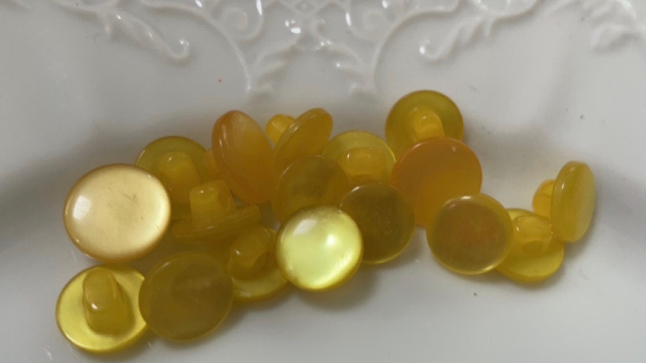 One dozen round yellow gold pearlescent vintage buttons