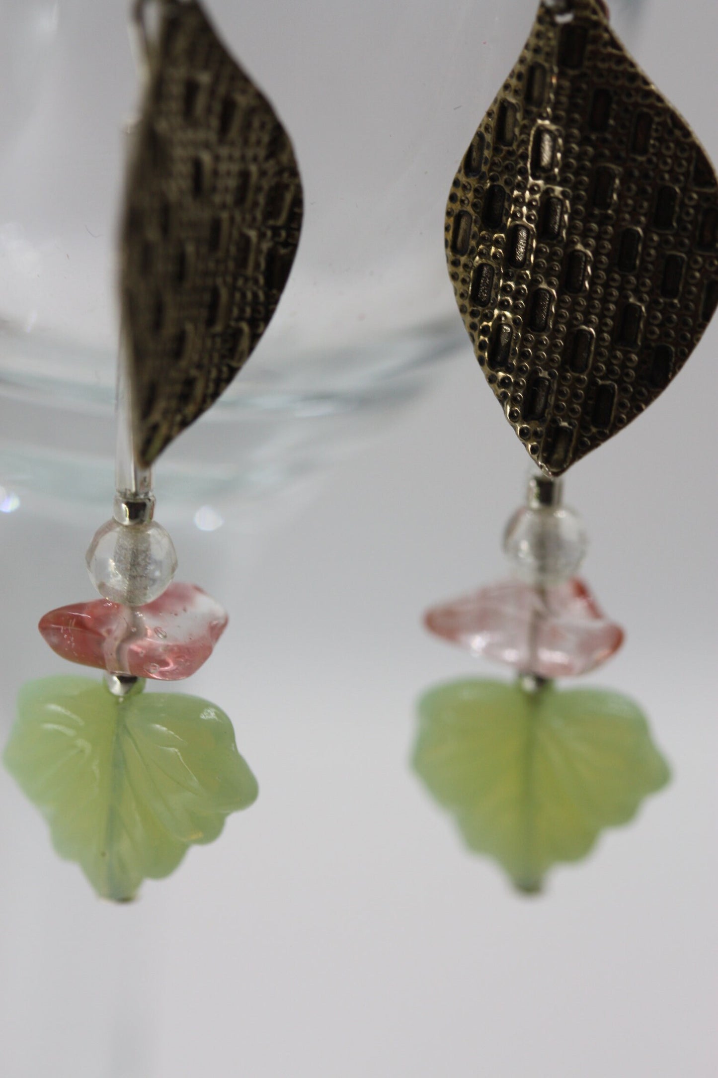Handmade dangle earrings made of vintage textured metal leaves, pink gemstone chips and light green opaline glass ginko flower leaves