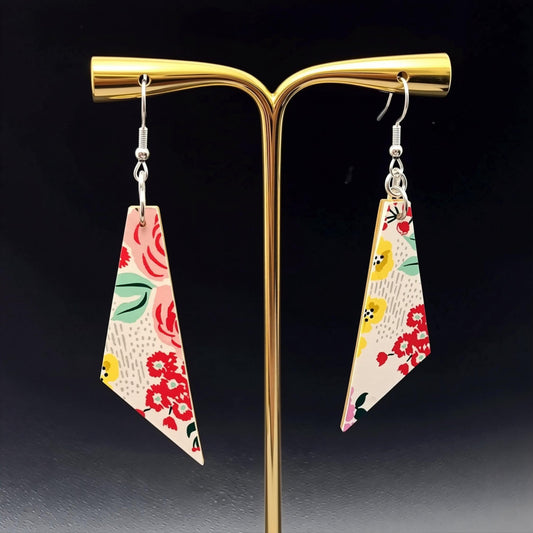 A pair of earrings with a floral pattern on a black background.