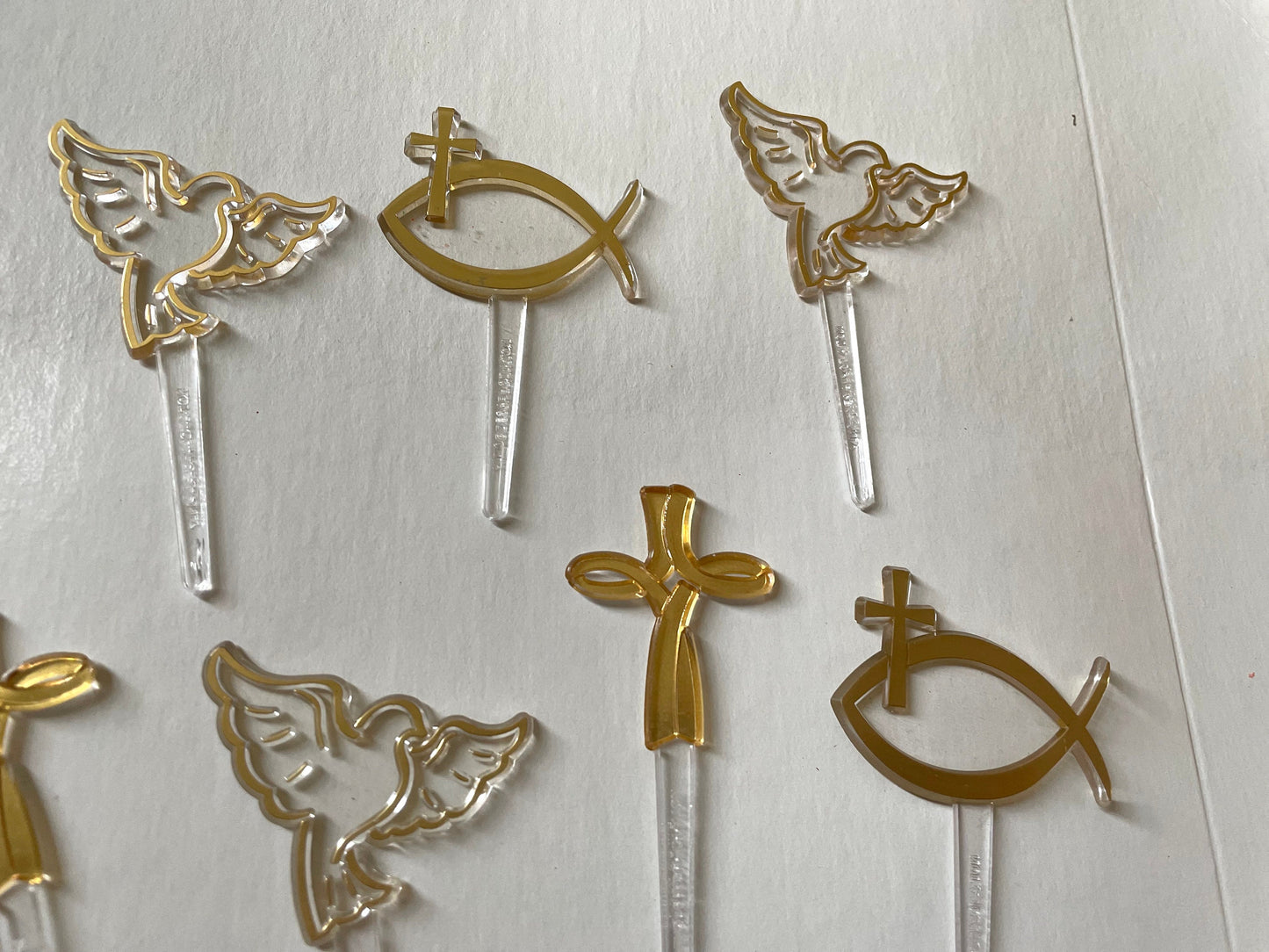 Mix of clear and gold plastic cake toppers - cross, fish and dove