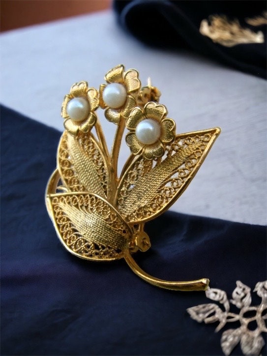 Detailed vintage filigree floral pin with faux pearls
