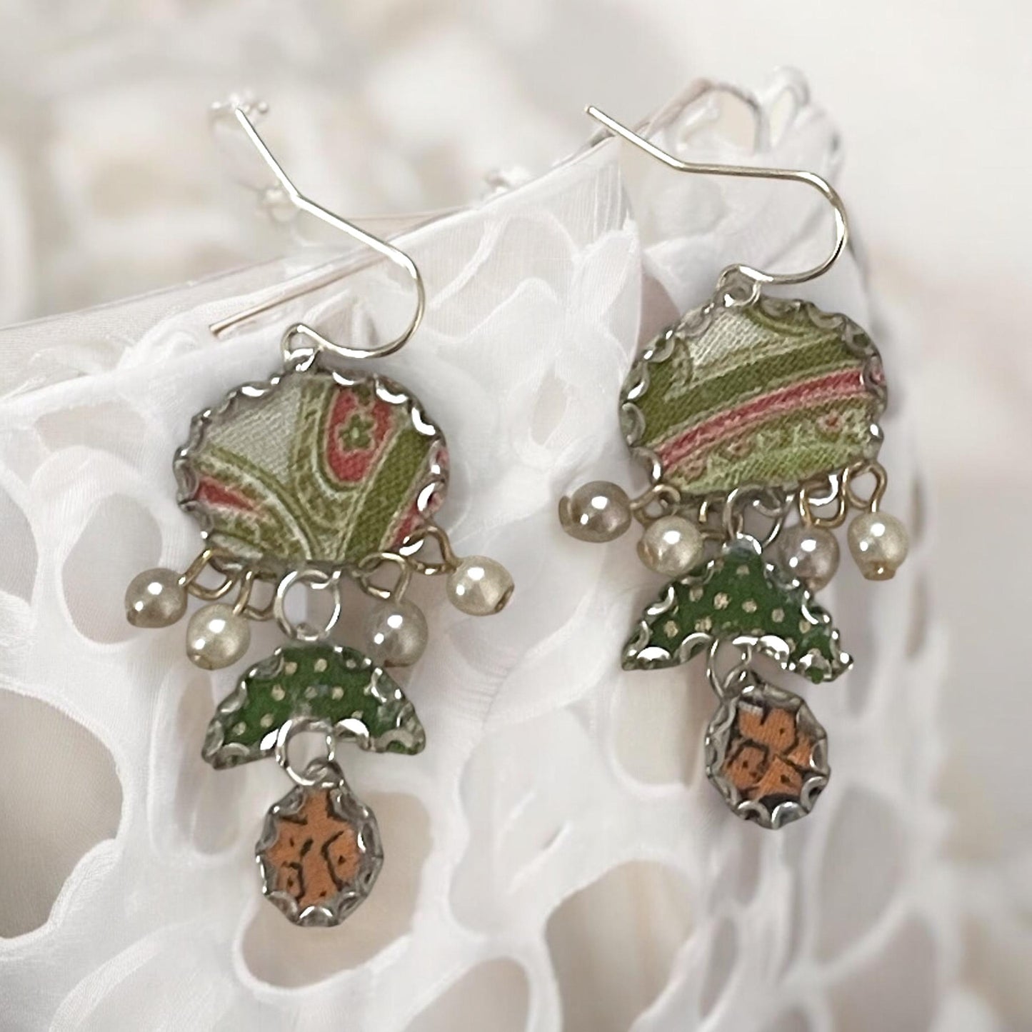 Handmade earrings featuring green and white polka dot fabric with peach and cream paisley and dangling faux pearls. Sterling ear wires.