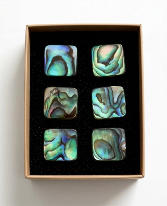 A set of six square-shaped objects with unique, colorful patterns, displayed in a black box with a white background.