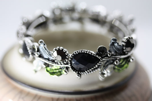 Stunning vintage costume jewelry cuff bracelet with black stones on silver with green leaves