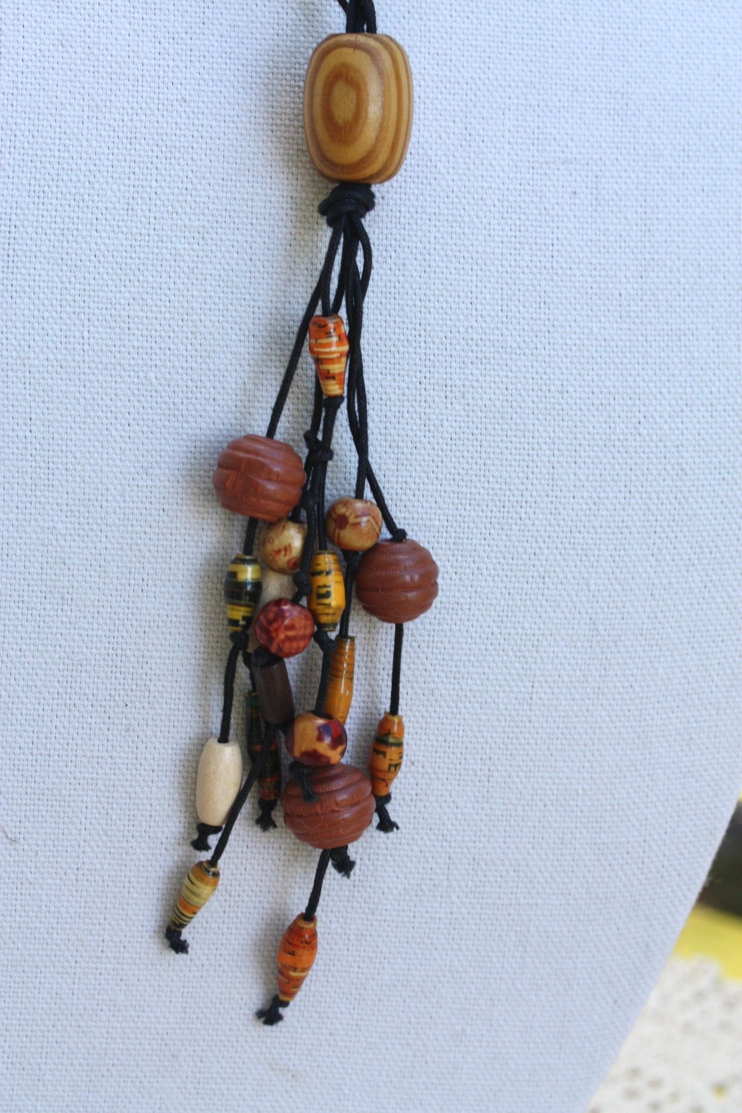 Long vintage wood, paper, glass mixed material vintage tassel necklace on black satin