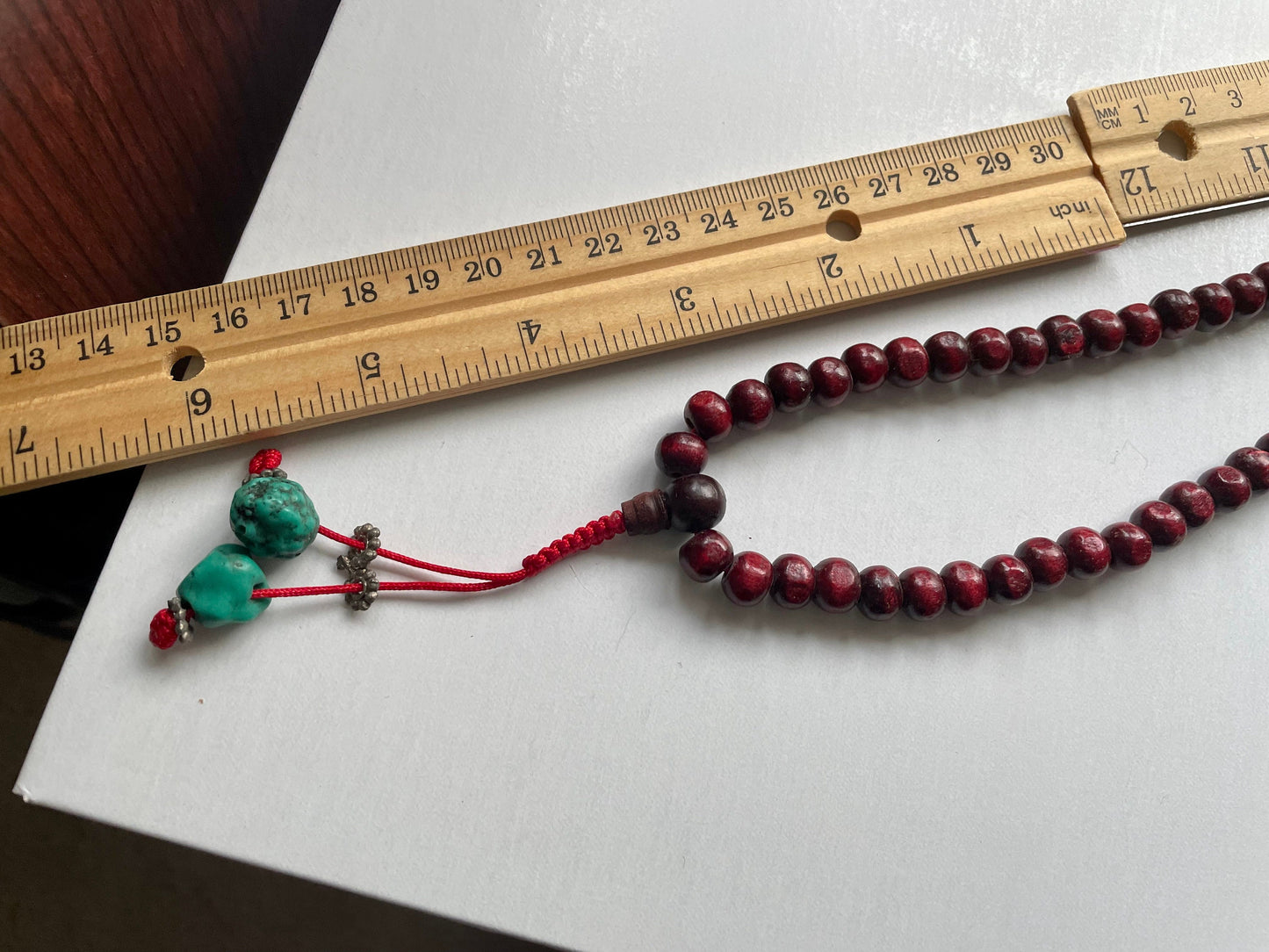 Long turquoise and wood vintage beaded necklace on red satin