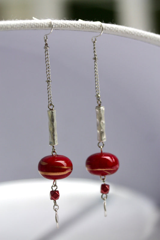 Long mixed material silver chain earrings with silver bars and red dangles, culminating in silver hammered discs