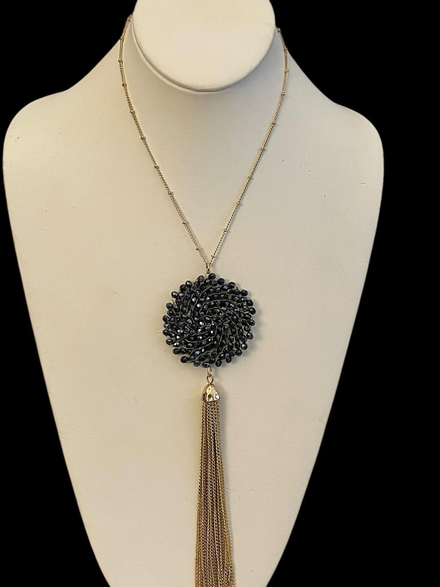Vintage necklace featuring a black crystal wire linked circular pendant with long goldtone tassel