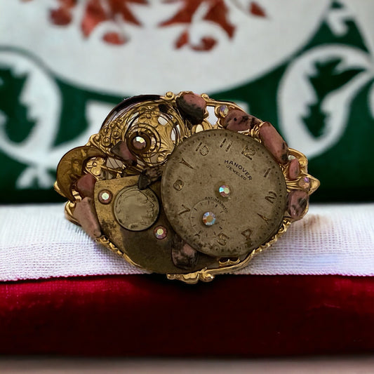 Assemblage art vintage pin with clock, rhinestones and other found pieces including semi precious stones on a filigree backing