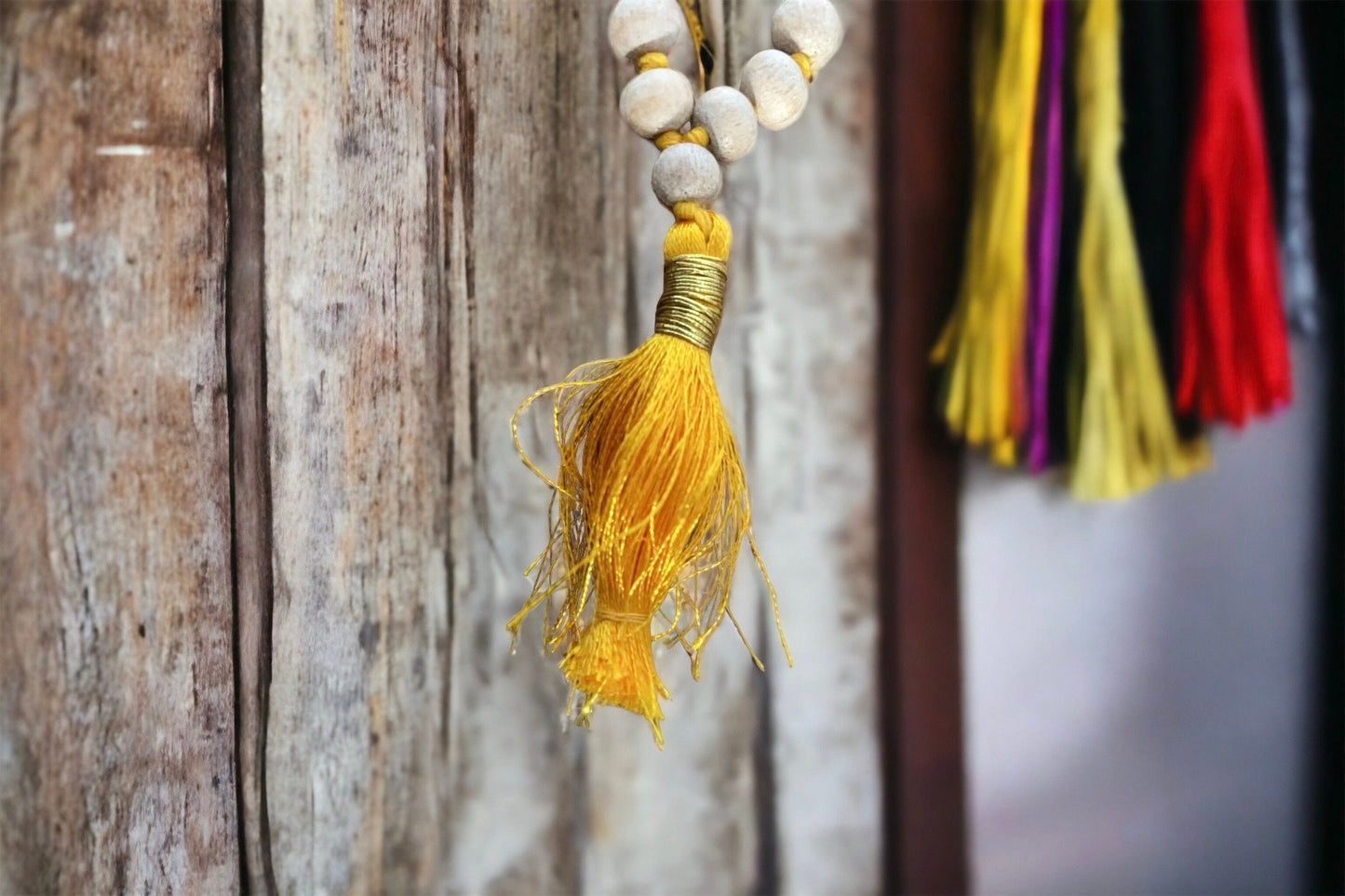 Knotted natural wood prayer bead necklace with golden yellow tassel