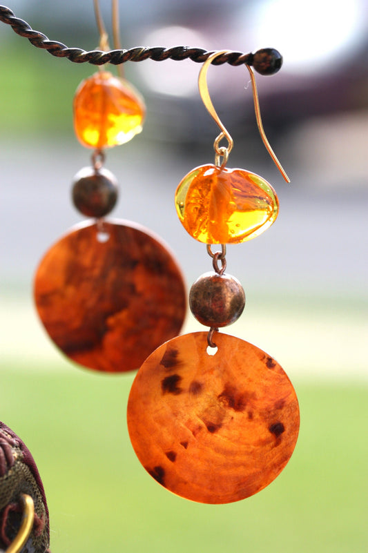 Handmade dangle earrings composed of upcycled orange blown glass, orange mother of pearl and copper beaded spacer beads