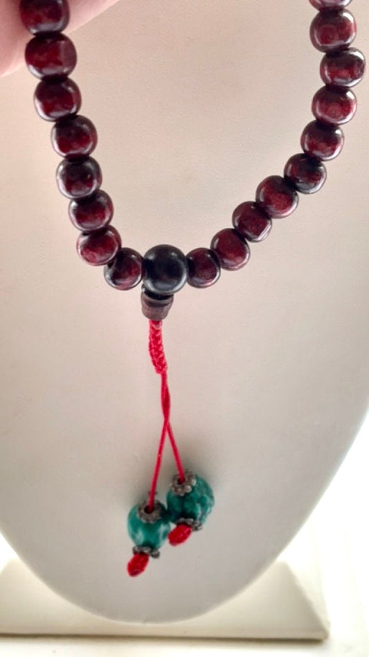 Long turquoise and wood vintage beaded necklace on red satin