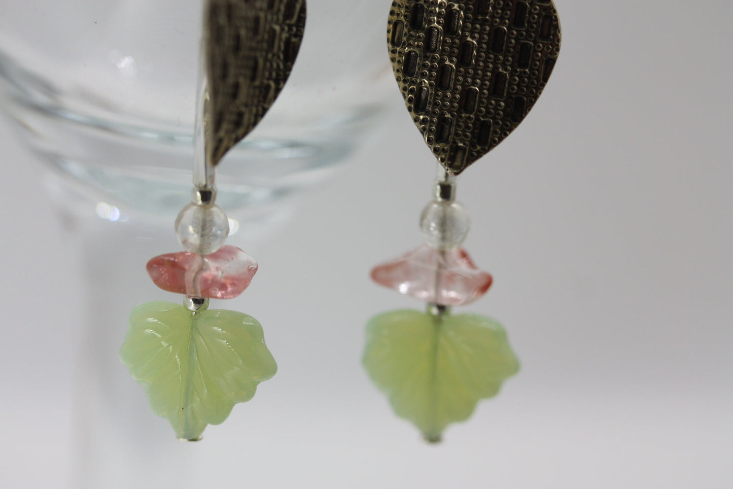 Handmade dangle earrings made of vintage textured metal leaves, pink gemstone chips and light green opaline glass ginko flower leaves