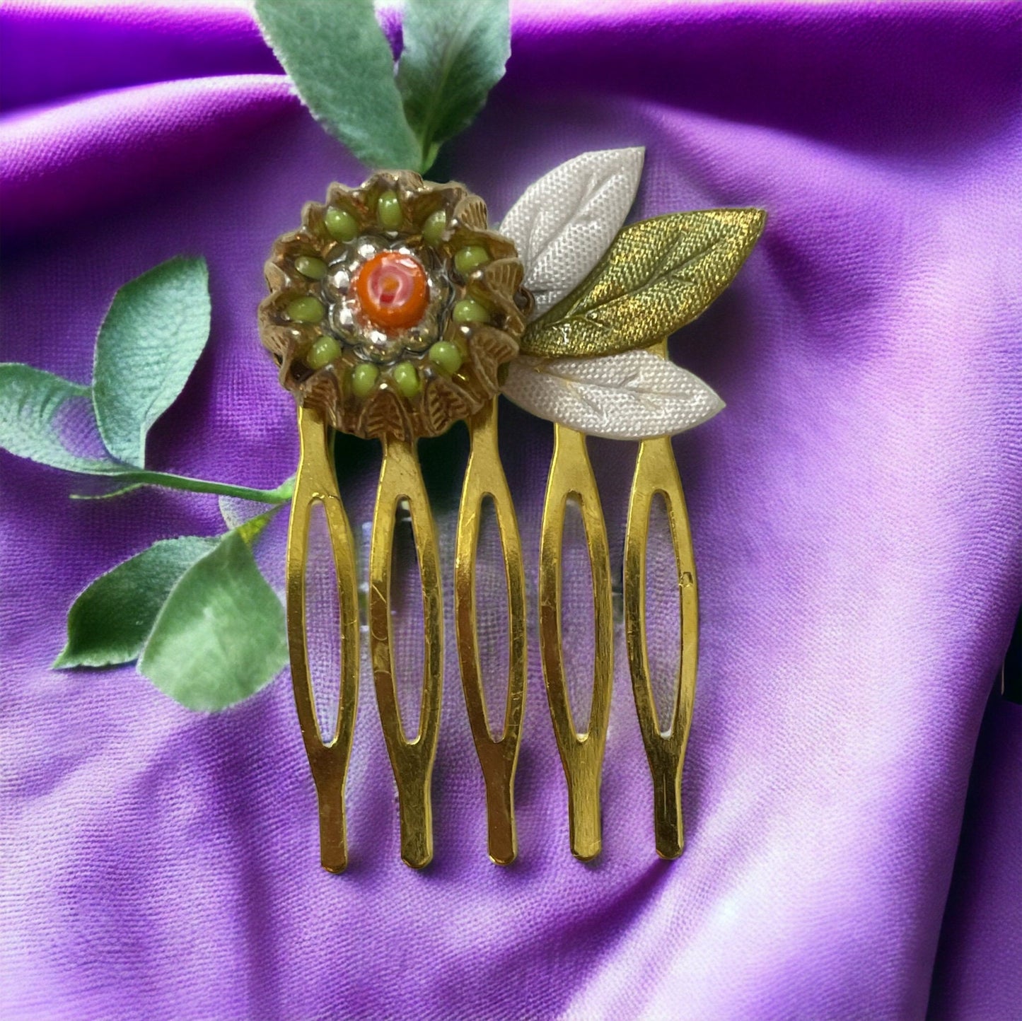 Small 1" hair comb featuring beaded mixed medium upcycled metal floral crown trimmed with satin green and white leaves.