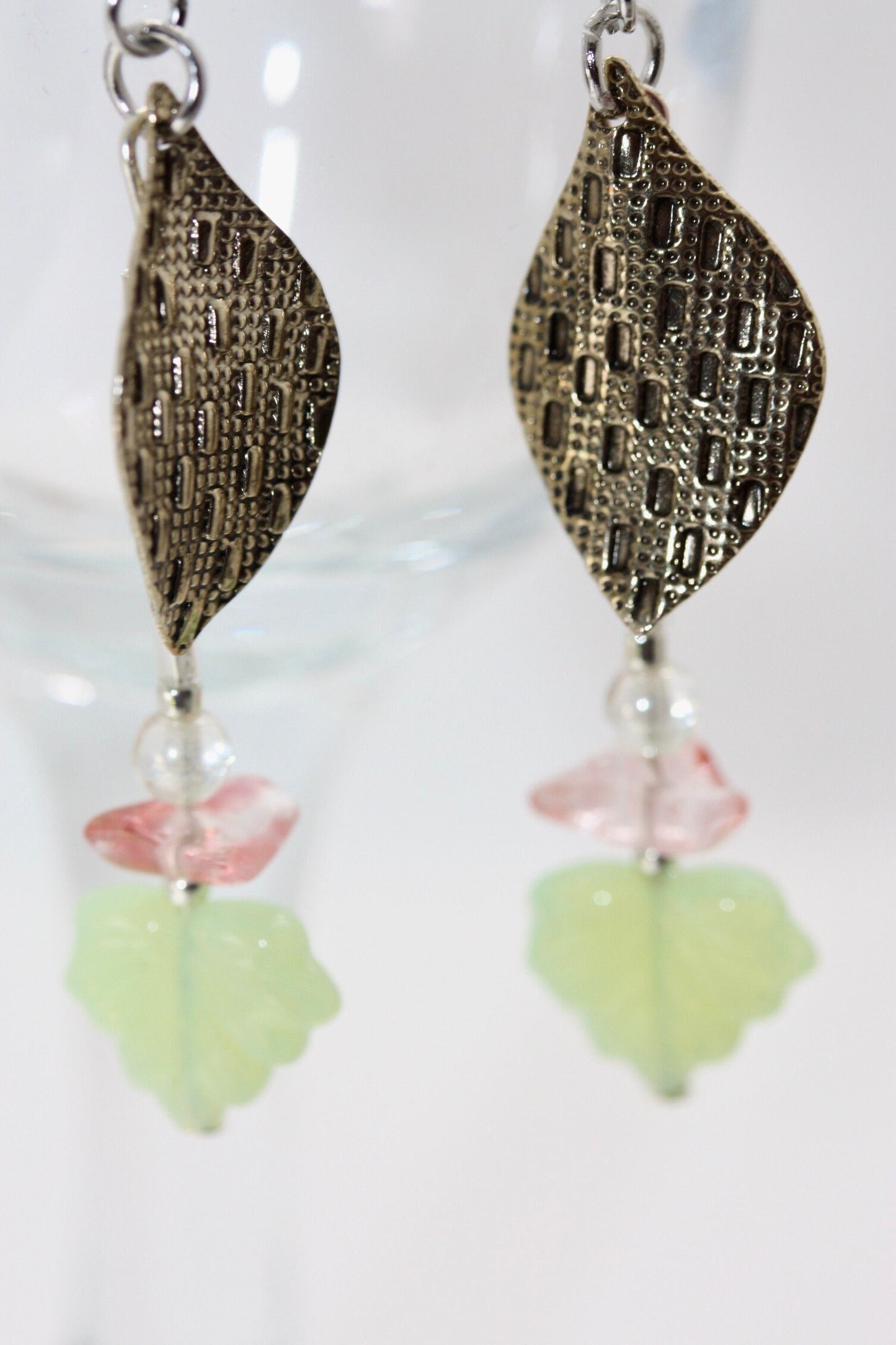 Handmade dangle earrings made of vintage textured metal leaves, pink gemstone chips and light green opaline glass ginko flower leaves