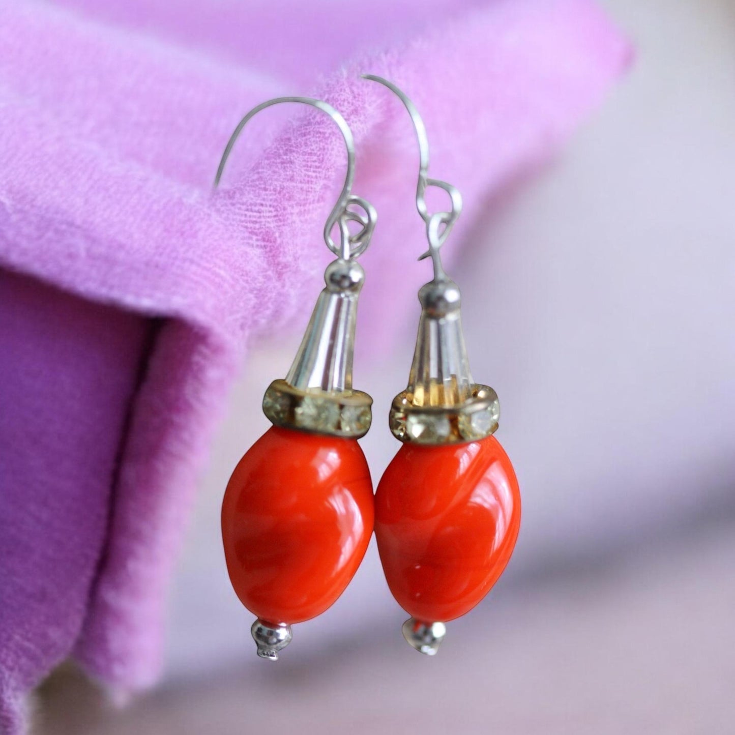 Unique dangle earrings featuring orange free form slightly twisted vintage glass, metal cone beads and rhinestone spacers