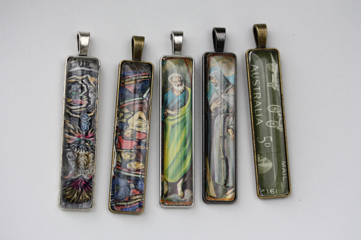 Necklace pendants made from genuine vintage and antique postage stamps from around the world - saints, Australian plane, Wicca  sun and moon