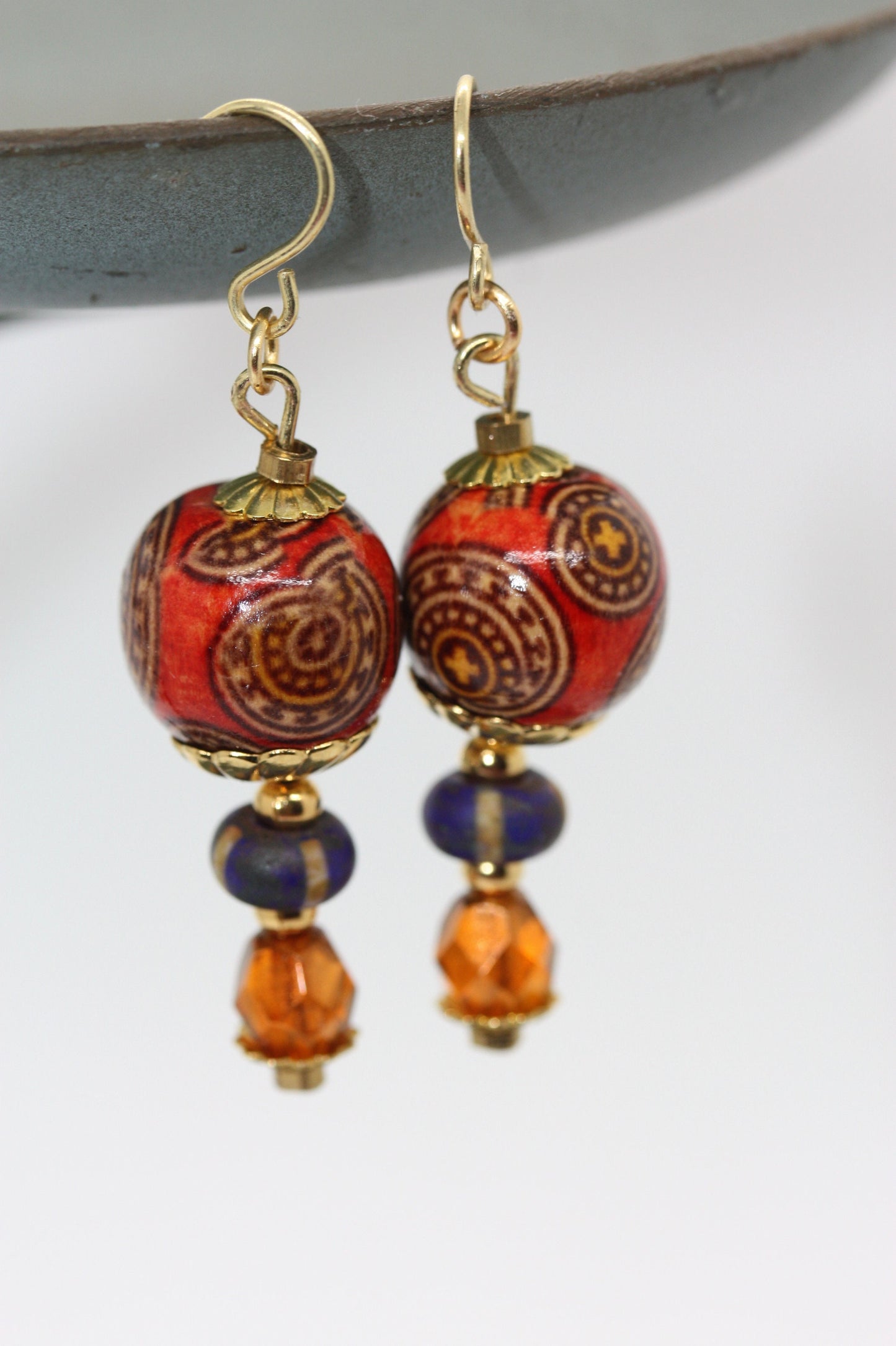 Burnt orange beaded earrings - paper covered beads, purple with cream stripes, orange fire polished crystals