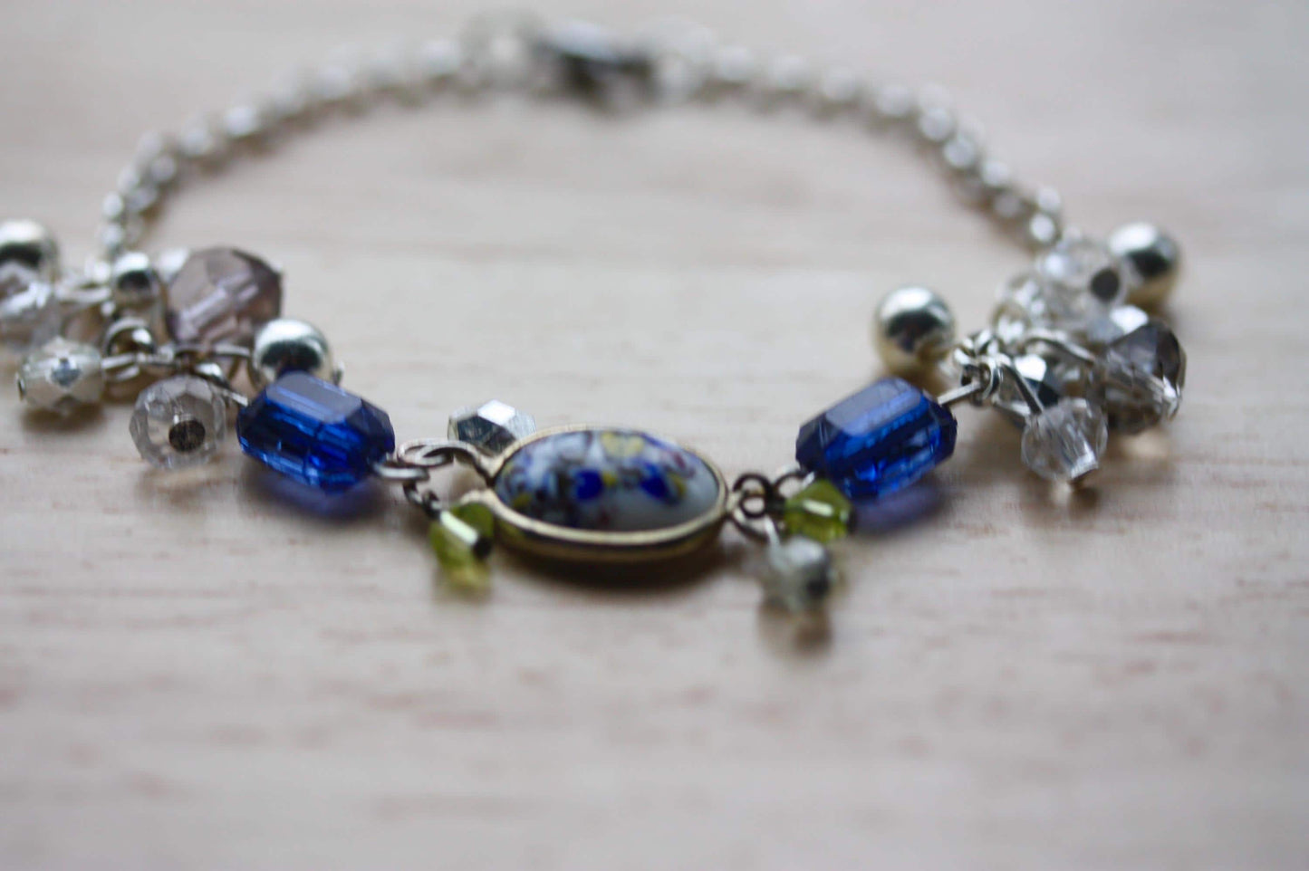 Handmade bracelet featuring a unique vintage art glass cabochon, royal blue faux crystals, yellow, pearl and clear crystal dangles - 7"