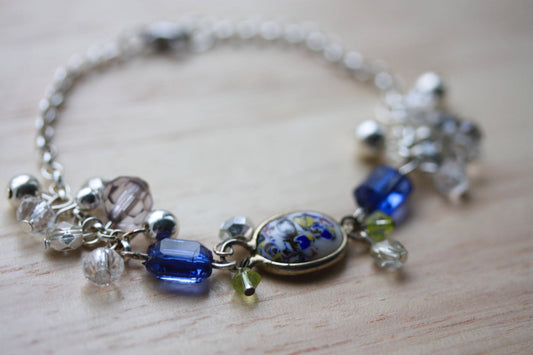 Handmade bracelet featuring a unique vintage art glass cabochon, royal blue faux crystals, yellow, pearl and clear crystal dangles - 7"