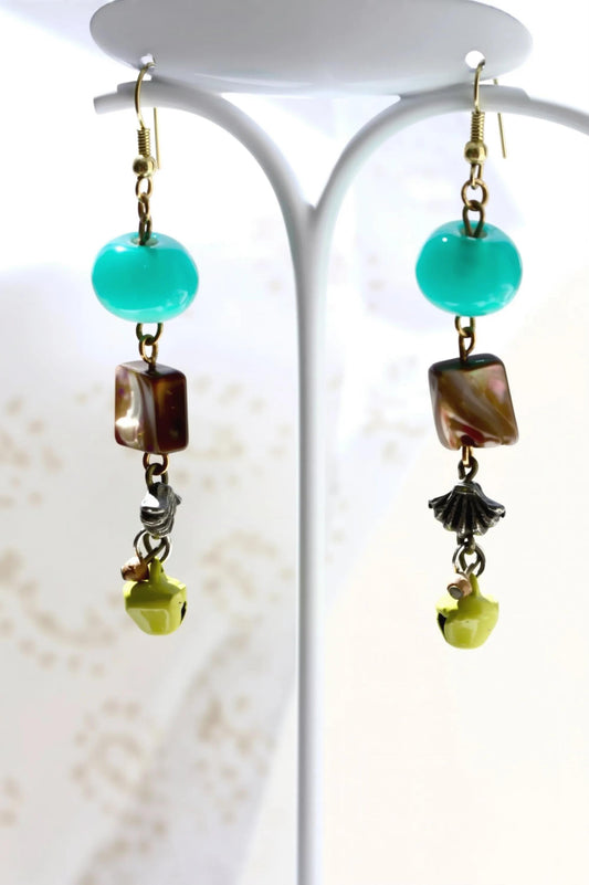 A pair of earrings with turquoise beads and various colorful beads hanging from the ear hooks.