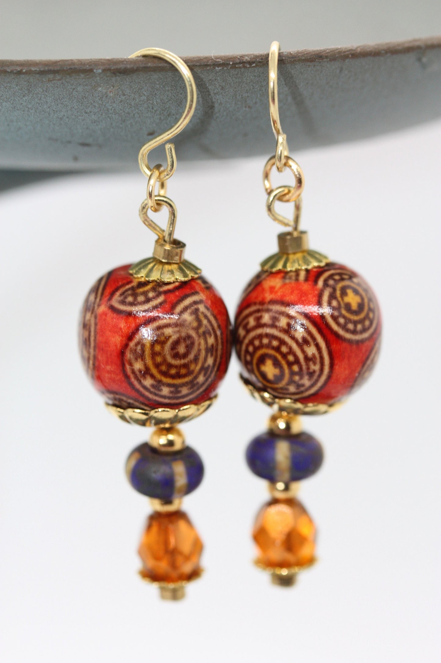 Burnt orange beaded earrings - paper covered beads, purple with cream stripes, orange fire polished crystals