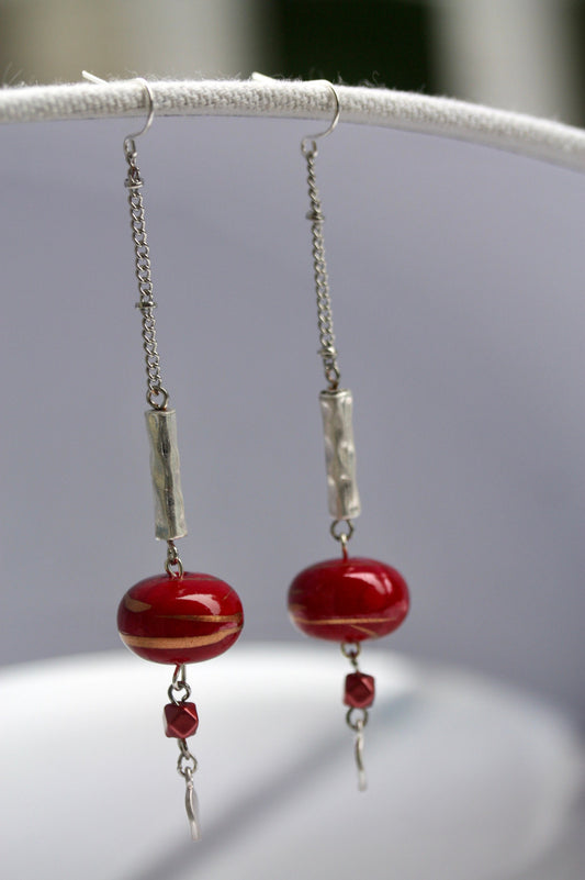 Long mixed material silver chain earrings with silver bars and red dangles, culminating in silver hammered discs