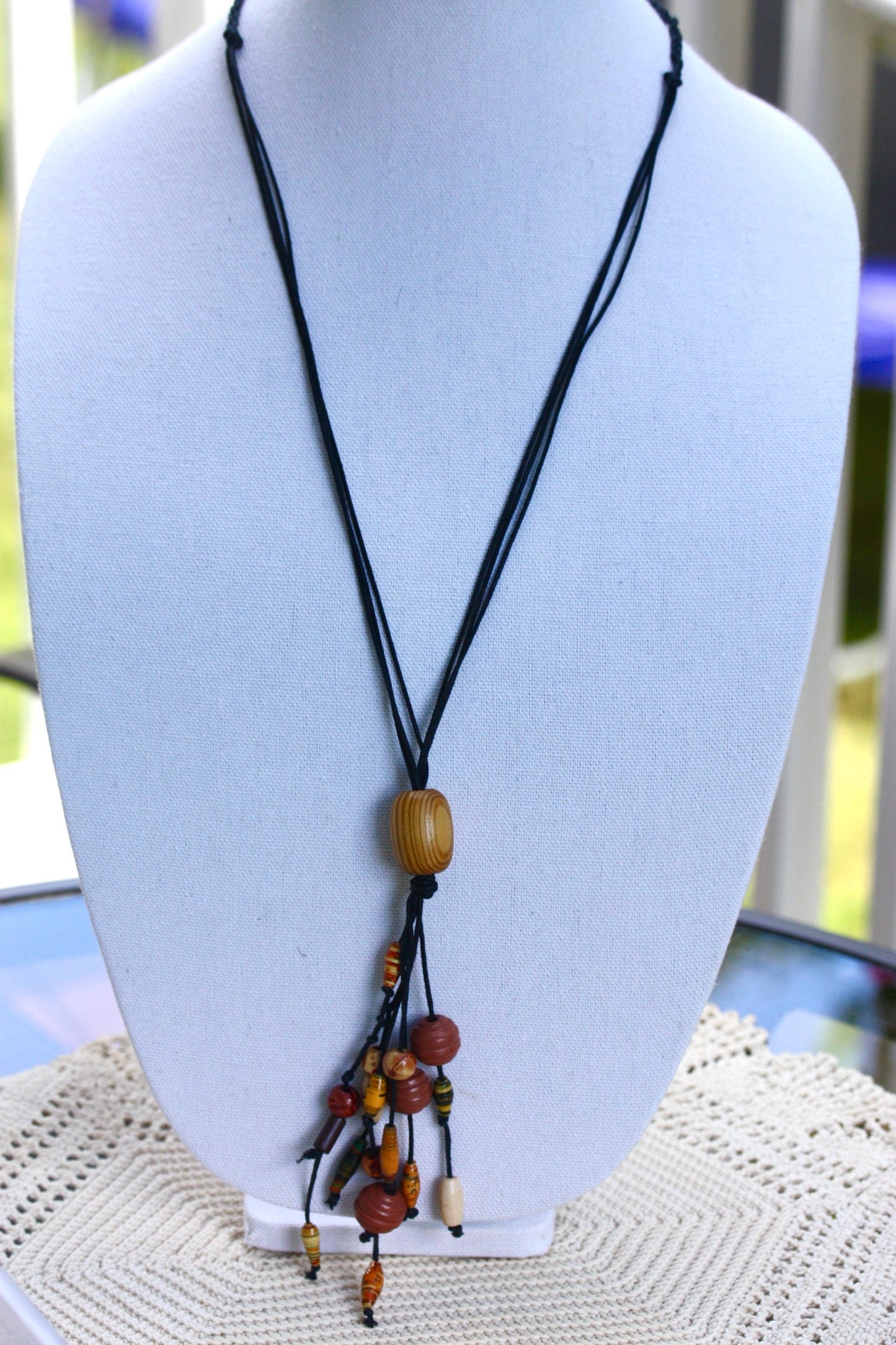 Long vintage wood, paper, glass mixed material vintage tassel necklace on black satin