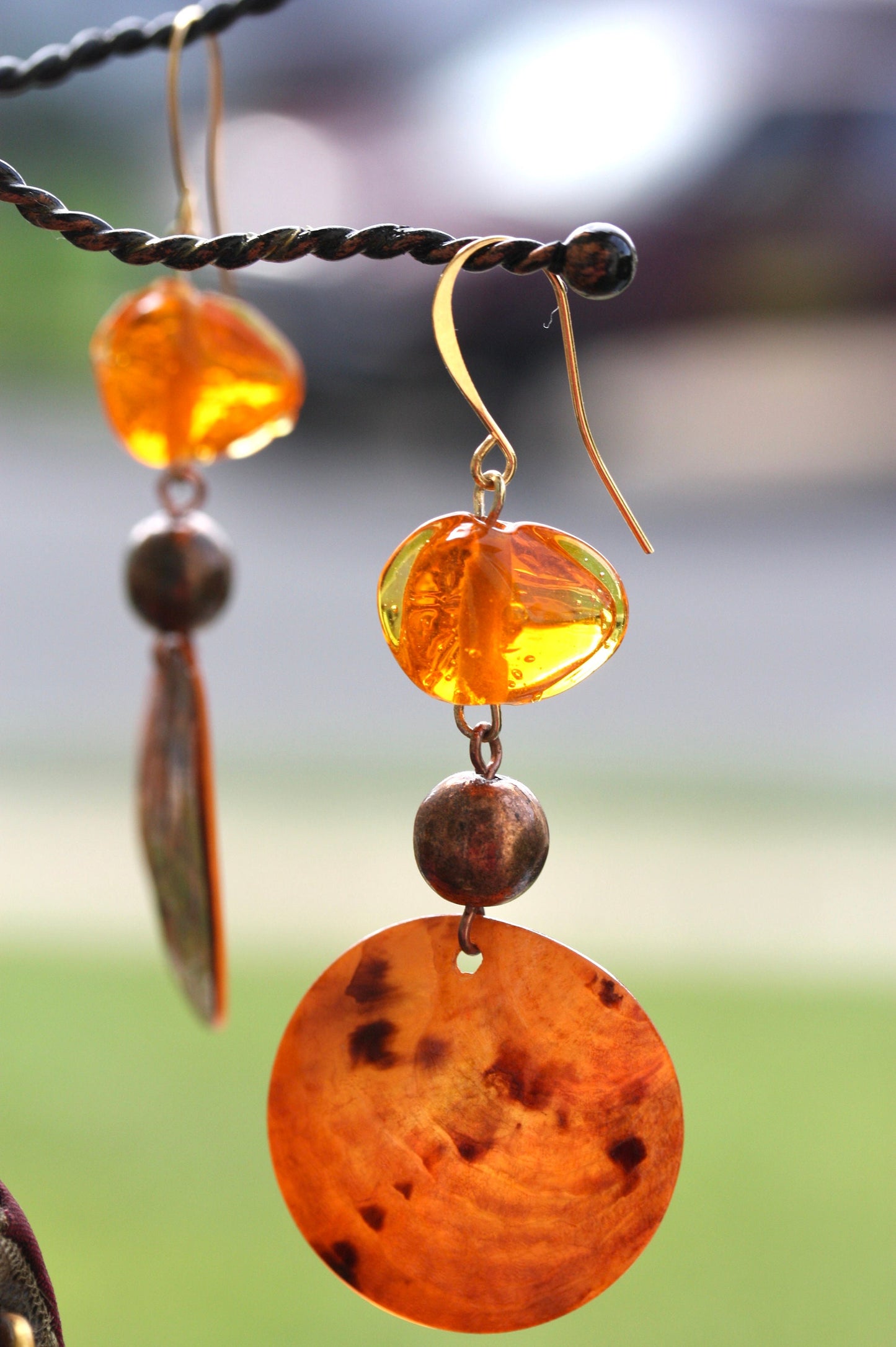 Handmade dangle earrings composed of upcycled orange blown glass, orange mother of pearl and copper beaded spacer beads