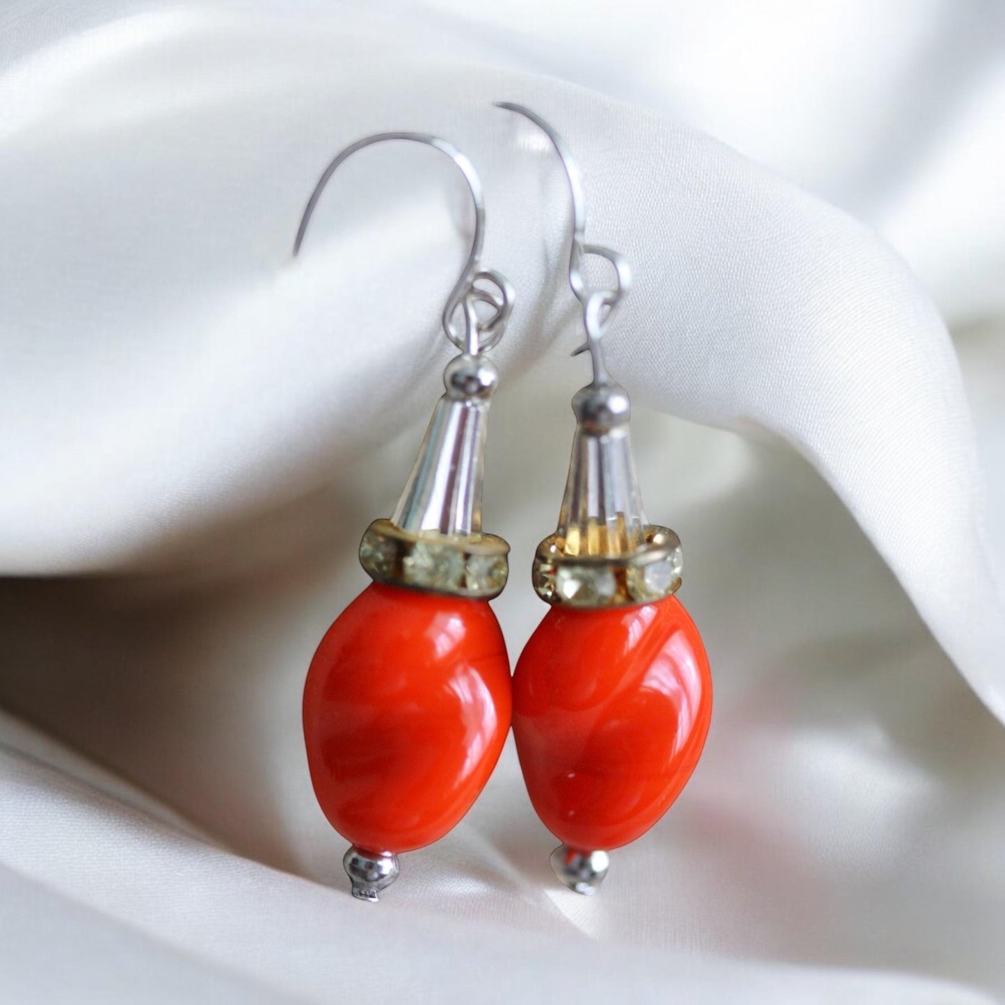 Unique dangle earrings featuring orange free form slightly twisted vintage glass, metal cone beads and rhinestone spacers