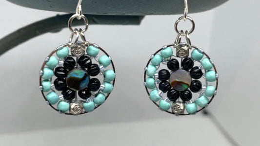 Small dangling handmade turquoise and black beadwork earrings with abalone centers