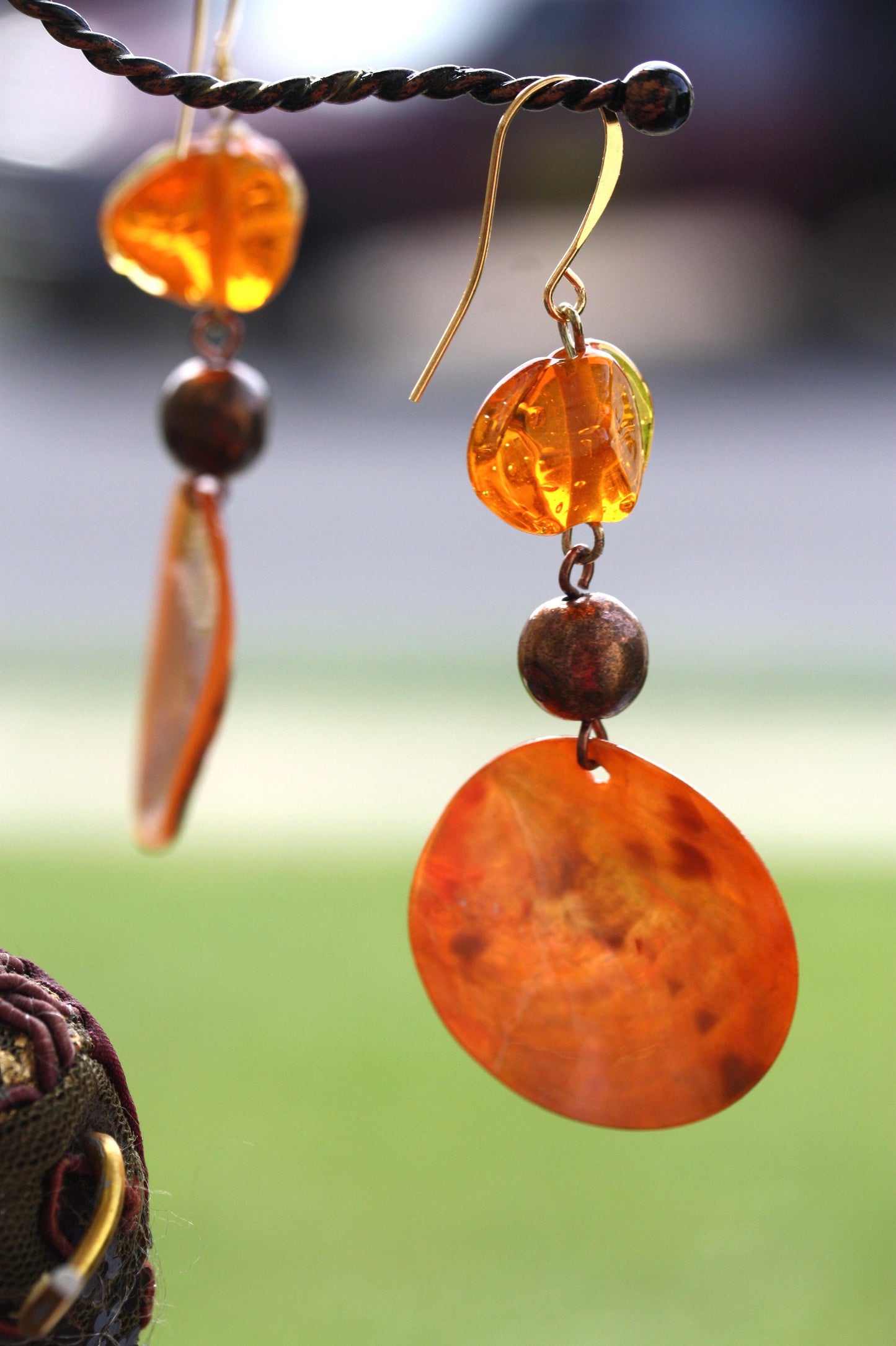 Handmade dangle earrings composed of upcycled orange blown glass, orange mother of pearl and copper beaded spacer beads