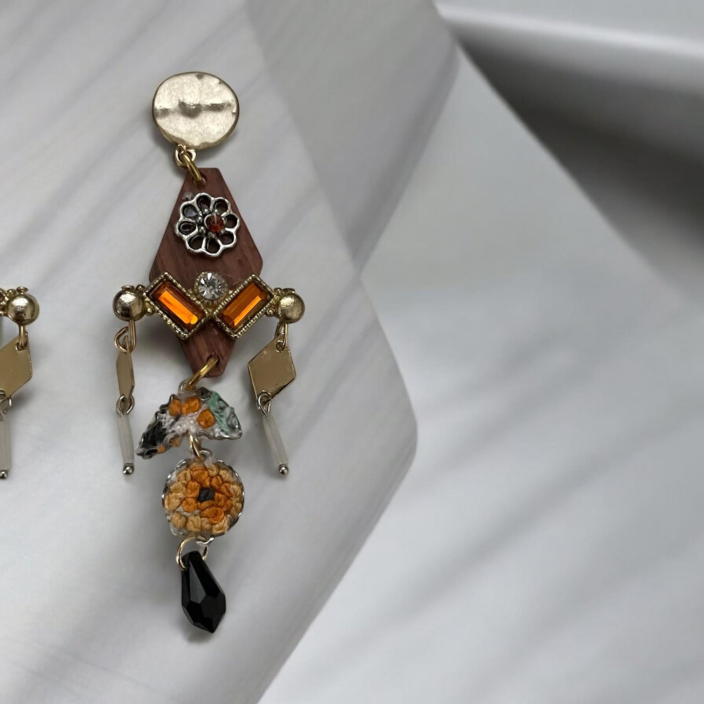 Mixed media earrings made with embroidery from a vintage linen table runner,  rosary wood, hammered metal, glass tubes, orange rhinestones