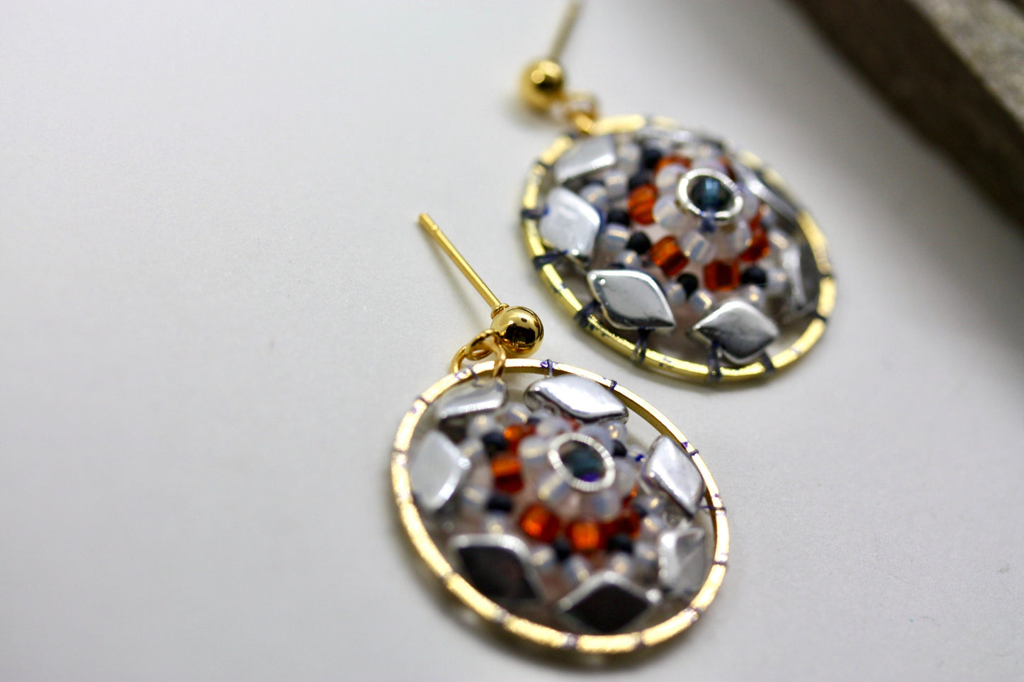 Orange and navy blue intricate beadwork small circular dangle earrings