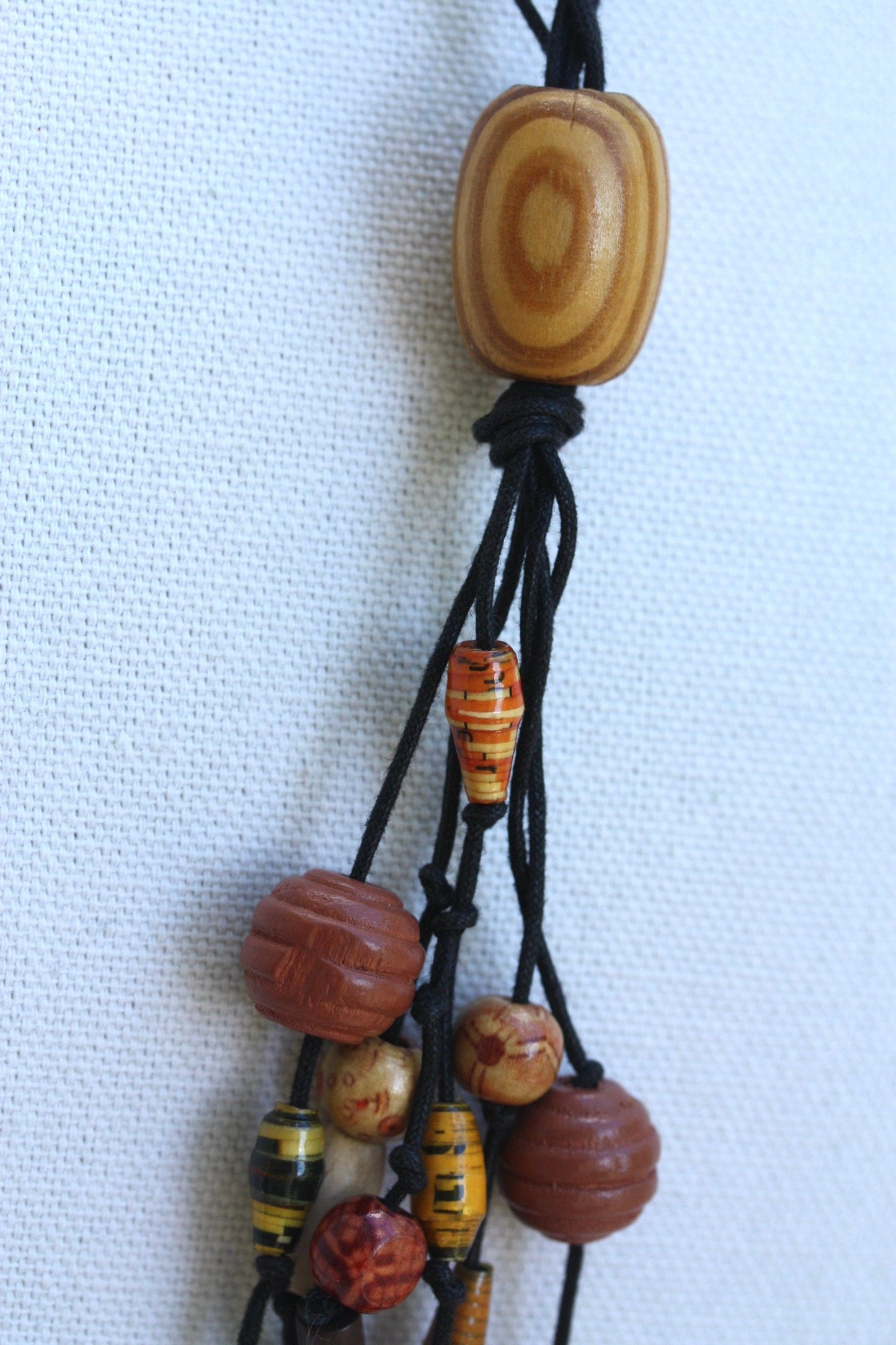 Long vintage wood, paper, glass mixed material vintage tassel necklace on black satin