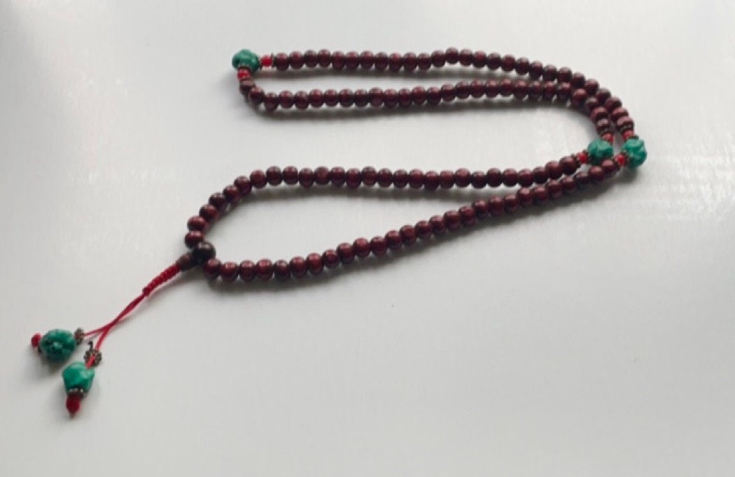 Long turquoise and wood vintage beaded necklace on red satin