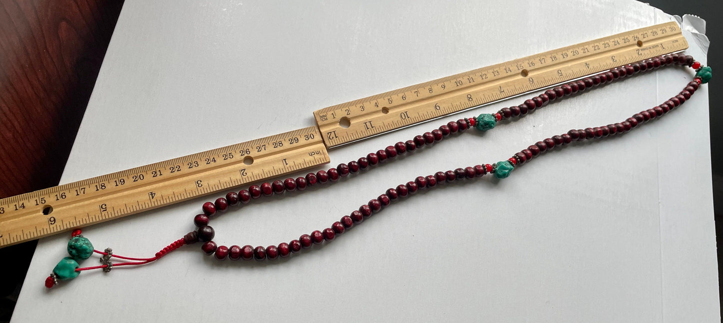 Long turquoise and wood vintage beaded necklace on red satin